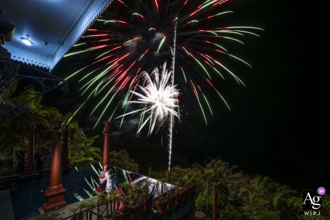   From a balcony at Zephyr Palace, Villa Caletas Hotel in Jaco, Costa Rica, the bride and groom watch fireworks light up the night sky as the grand finale of their celebration.