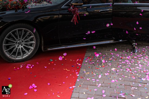 Red Carpet Signals Car Arrival or Departure Outside a Family Home in Binzhou Shandong China In Binzhou, Shandong, outside a family home, a person steps out of a vehicle at the red carpet, signaling either an arrival or departure associated with the wedding day activities.