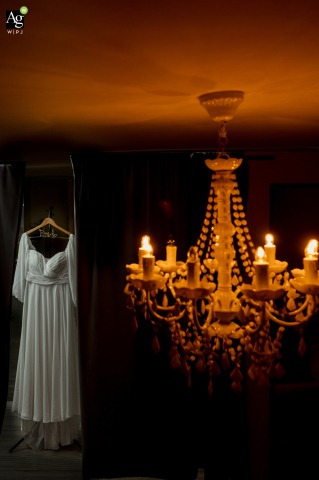 Wedding Dress Illuminated by Cool and Warm Contrasts at Playa del Carmen In a room at Playa del Carmen, a wedding dress hangs in a doorway, lit by cool-toned light, while the adjacent main room is bathed in a contrasting warm glow.