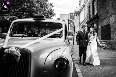   On Barrington Road in Brixton, England, the couple strolls past the vintage London taxi that brought them, with the city’s charm adding character to their portrait.