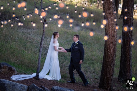 Bride and Groom Enjoy a Joyful Private Pause Outside Under String Lights Before Reception at The Pines in Golden Colorado At The Pines in Golden, Colorado, the bride and groom enjoy a quiet, joyful pause together before their wedding reception, sharing a private glance away from the festivities and under the strings of warm lights.