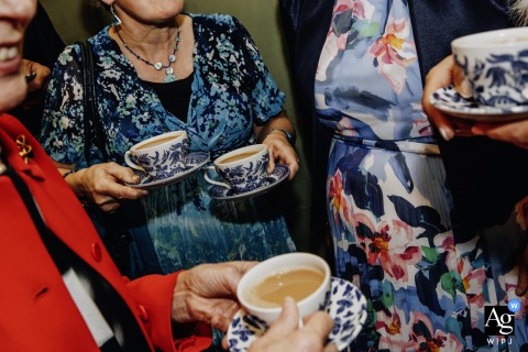 Wedding Guests At Shortflatt Tower In Northumberland Hold Tea Cups, Reflecting A Classic And Timeless British Wedding Atmosphere Guests at Shortflatt Tower in Northumberland, UK, gather with tea cups in hand, the elegant gathering reflecting a classic British wedding tradition.