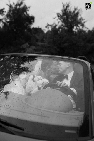 Couple Finds Joy Posing in a Convertible Despite Gentle Rain at Croatian Park in Franklin Wisconsin At Croatian Park in Franklin, Wisconsin, the couple poses inside the groom’s grandfather’s convertible, finding joy together despite a gentle rain during their wedding photo session.