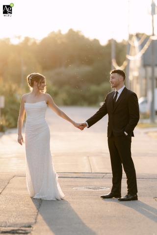 Sunset Behind Trees at Prairie Springs on Park in Milwaukee Wisconsin Bathes Couple in Golden Haze As the sun sets behind the trees at Prairie Springs on Park in Milwaukee, Wisconsin, a warm haze fills the scene while the couple walks together across the road.