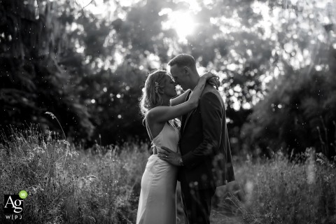 A Radiant Kiss Shared in the Rain at Château Destinée Illuminates the French Setting A kiss is shared in the rain while sunshine glows behind them at Château Destinée, France, giving the bride and groom’s embrace a magical, radiant atmosphere.