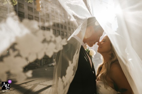 Streets Of Downtown Cleveland Bathed In Winter Sunlight, The Couple Shares A Kiss Highlighted By Golden Rays The streets of downtown Cleveland are bathed in end-of-year sunlight, with winter’s golden rays highlighting the couple during their wedding day kiss.
