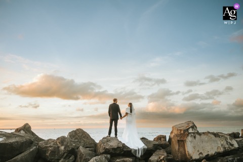 Portrait Of Bride And Groom Posing On Rocks With Dramatic Composition In Ohio, Her High Heels Showing Adventurous Spirit Climbing rocks at a picture location in Ohio, the bride and groom pose together for a dramatic composition, with her high heels emphasizing the adventurous spirit of the session.