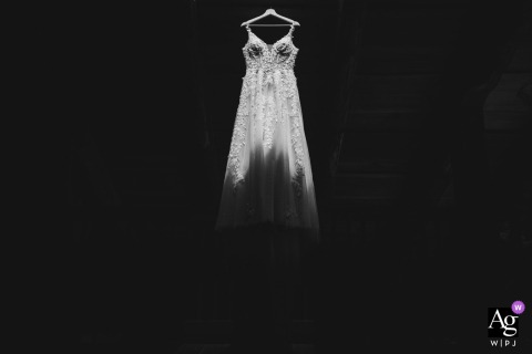 Glowing Sunbeam Illuminates The Wedding Dress At The Mohicans Treehouse Resort In Ohio, Emphasizing Memorable Detail And Texture A shaft of sunlight illuminates the wedding dress at The Mohicans Treehouse Resort in Loudonville, Ohio, the glow highlighting its texture for a memorable detail shot.
