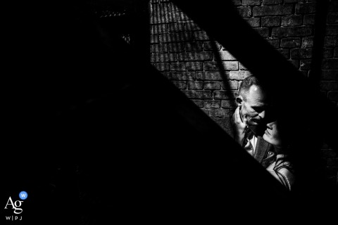   At the reception venue in Leiden, Zuid Holland, dramatic light illuminates the couple, creating a romantic focal point as they stand together.