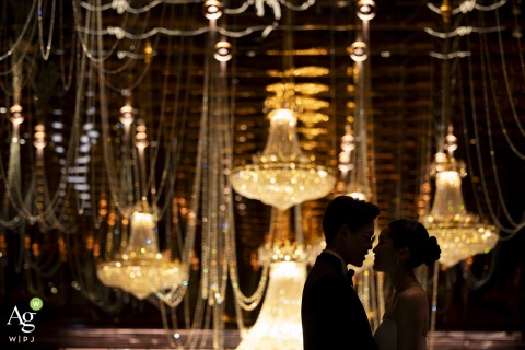 Silhouetted Couple Stands Together At Asia Hotel Bangkok Romance Against Softly Lit Backdrop A silhouetted couple stands together at Asia Hotel in Bangkok, their outlines set against a softly lit backdrop, highlighting romance and anticipation before the celebration.