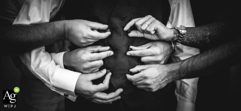 Several Hands Button Groom’s Vest For Ceremony Preparation At Vezzano Ligure Liguria At Vezzano Ligure in Liguria, the groom’s vest is buttoned by several hands in a detailed shot, emphasizing teamwork and support just before the ceremony.