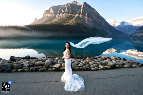   A view of the bride with veil flowing at Lake Louise, Canada.