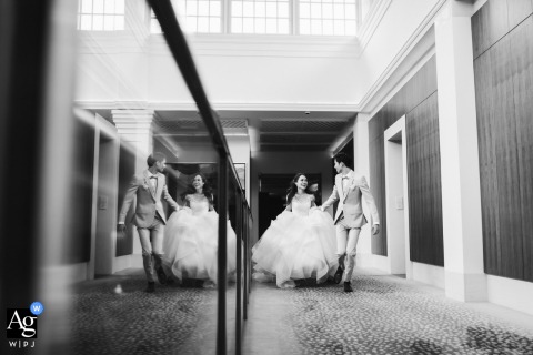 Hand In Hand, The Couple Runs Through The Capitol Kempinski Hotel Singapore, Surrounded By Elegant Modern Decor The couple runs hand in hand across The Capitol Kempinski Hotel in Singapore, the elegant surroundings framing their sense of excitement for their future together.