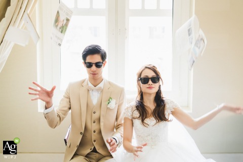 Couple Toss Wedding Invites Filling Ceremony Room With Energy At Kempinski Hotel Singapore Inside The Capitol Kempinski Hotel in Singapore, the couple tosses their wedding invitations and décor into the air, their lively energy filling the ceremony space.