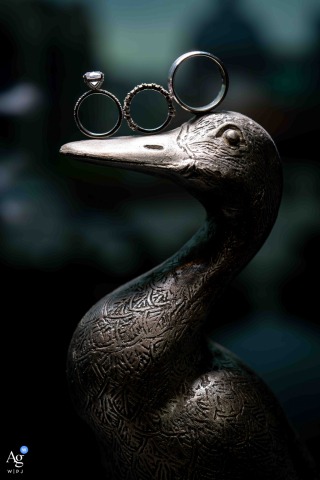 Wedding Rings Rest On A Duck Statue’s Beak At The Mandarin Oriental, Taipei, Offering Whimsical Charm To The Detail Shot Within the same grand hotel, a duck statue holds the wedding rings on its beak, adding a whimsical and memorable touch to the ring presentation detail.