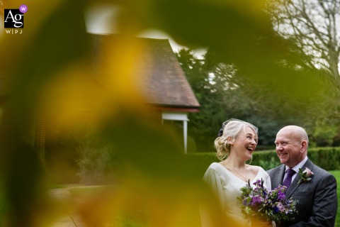 Laughter Sparkles In The Portrait Of The Bride And Groom Standing Together At Pendley Manor In Buckinghamshire Laughter fills the air as the bride and groom stand together at Pendley Manor, their bright expressions adding warmth and energy to the wedding portrait.