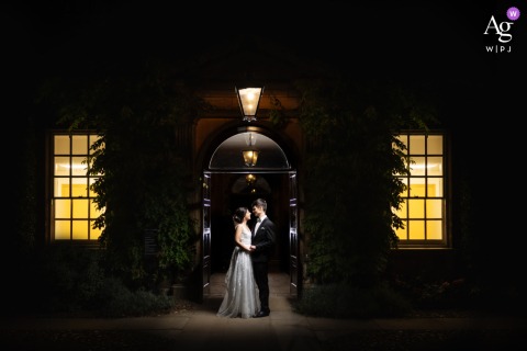 Couple Posed Under Night Sky Amid Historic Architecture At Trinity Hall College Under the night sky at Trinity Hall College, a striking portrait captures the couple amid the historic architecture, their outlines softly illuminated by evening light.