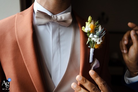 Close-Up Of Groom’s Boutonniere Highlighting Floral Detail At Domaine De Grand Maison Isère Set at Domaine de Grand Maison en Isère, a close-up draws focus to the groom’s boutonniere, revealing delicate textures and floral detail against his suit.