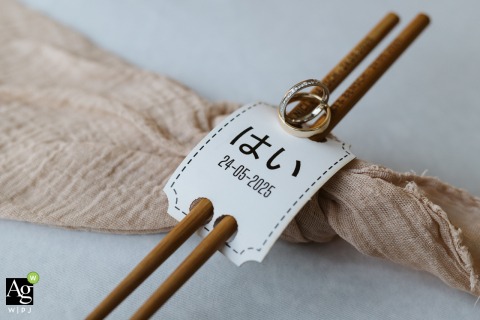 Wedding Rings And Engraved Chopsticks Displayed In Detail Shot At Firlingerhof Austria Reception In the reception space at Firlingerhof, Austria, wedding rings and engraved chopsticks meant as guest favors are thoughtfully displayed, blending tradition with personalized touches.