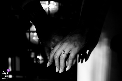 Bride’s Hand Emerges From Shadows Highlighting Sparkling Ring At Chignat France From the ceremony in Chignat, France, the bride’s hand emerges from the shadows, drawing attention to her sparkling wedding ring and the contrast between light and dark.