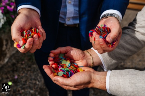 Guests Gather With Confetti In Hands For Colorful Celebration At Woolas Barn York England At Woolas Barn in York, England, wedding guests gather with hands filled with confetti, preparing for a colorful celebration during a joyful group detail shot.