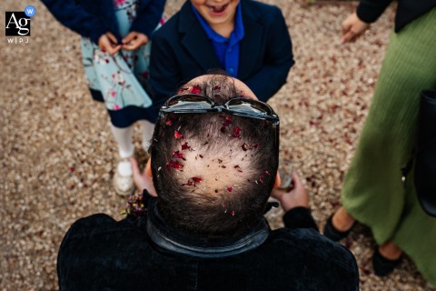   The groom’s head is adorned with confetti at High Billinghurst Farm Wedding Venue in Surrey, England, a vibrant detail celebrating the joy of the wedding day.