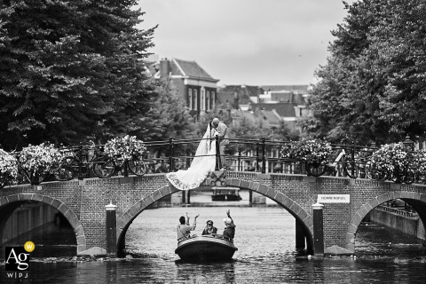 Couple Shares Kiss On Bridge As Boat Passes Below In Charming Leiden In the city of Leiden, the couple shares a kiss on a bridge as a boat drifts by below, capturing the charm of urban waterways and romantic architecture.