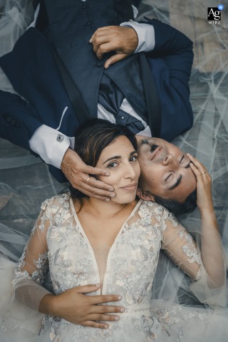 Wedding Couple Lays Together In Intimate Portrait At Riccò Del Golfo Liguria At Riccò del Golfo in Liguria, the wedding couple lays together in an intimate portrait, the scenic Italian setting emphasizing their close connection.