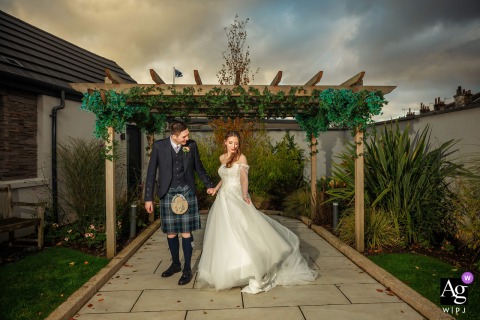 Bride And Groom Illuminated By Flash Against Glowing Sunset At Redhurst Hotel At The Redhurst Hotel, the bride and groom are illuminated by off-camera flash against the sunset, their figures standing out vividly as the sky glows behind them.