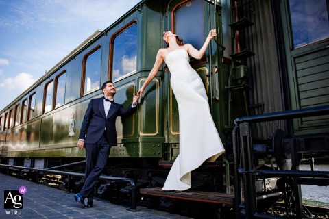Couple Poses In Front Of Vintage Train At Koc Museum Istanbul Wedding Portrait The couple poses in front of an old train at Koc Museum in Istanbul, the vintage locomotive adding texture and historical charm to their wedding portrait.