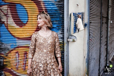 Broken Street Mirror Creatively Reflects Groom as Couple Wanders Old Town of Tahtakale, Eminonu, Istanbul Wandering through the Old Town in Tahtakale, Eminonu, Istanbul, a couple’s session is creatively mirrored by the fractured reflection of the groom in a broken street mirror.
