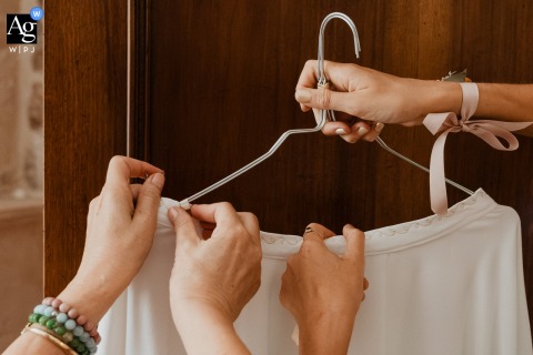 Close-Up Of Hands Preparing Bride’s Outfit At Domaine Des Loups Niort France A close-up at Domaine des Loups, Niort, France, focuses on hands carefully preparing the bride’s outfit, capturing a delicate detail of the preparation process.
