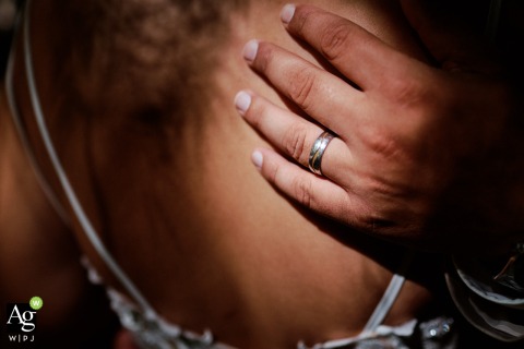 Groom’s Ring Gleams on Bride’s Bare Back in Sunlit Forest Clearing in Fribourg, Switzerland In a quiet patch of forest in Fribourg, Switzerland, the groom’s wedding ring gleams in a single ray of sunlight on the brides bare back.