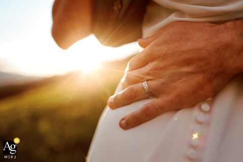 Sunlight Illuminates Groom’s Wedding Band Highlighting Meaningful Detail In Fribourg Sunlight shines behind the groom’s wedding band at the reception venue, drawing attention to this meaningful detail as it glimmers with the promise of the day in Fribourg.
