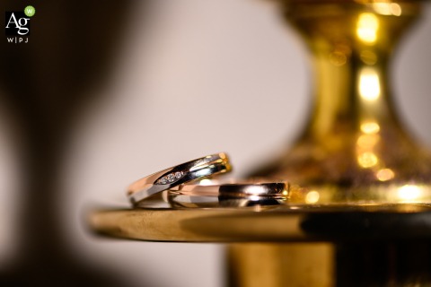 Simple Wedding Rings Gleam Softly on Golden Metal at Mariënhof Amersfoort, Highlighting Commitment in the Netherlands Two simple wedding rings lie on a small metal surface at Mariënhof Amersfoort in the Netherlands, softly gleaming and reflecting a sense of commitment.