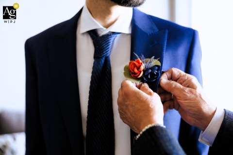 Quiet Groom Receives Final Pin In South Lake Tahoe Before Ceremony Begins In South Lake Tahoe, the groom receives a final pin from steady hands, this close-up detail capturing a quiet moment of anticipation before the ceremony begins.
