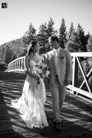 Couple Walks Hand in Hand and Laughs on a Bridge in South Lake Tahoe, California, Together in Joy Hand in hand, a couple strolls across a bridge in South Lake Tahoe, their happy smiles and easy laughter showing their world is just for two.