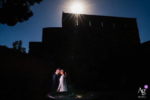 Sunbathed Couple Within The Storied Moorish Walls Of The Alcazaba De Málaga Another portrait of the couple features them in the Alcazaba de Málaga, Málaga, Spain, surrounded by the storied walls and sunbathed heritage of this renowned Moorish fortress.