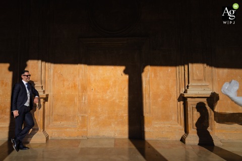 Couple Poses Together in Sun and Shadows at La Alhambra in Granada, Spain, Framed by Warm Colors and Historic Architecture The couple pose together at La Alhambra in Granada, Spain, framed by the warm colors and historic architecture of the iconic Andalusian landmark.