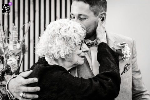 Heartfelt Embrace Between Groom And Grandmother At Claix Town Hall In France During a heartfelt family moment at Claix town hall in Claix, France, the groom shares a warm embrace with his grandmother, expressing affection and generational love.