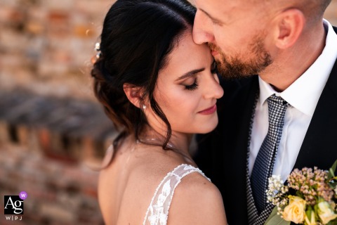 Groom Gently Kisses Bride’s Forehead In Intimate Udine Italy Wedding Day Portrait The groom gently kisses the bride’s forehead in an intimate, close-up portrait taken in Udine, Italy, capturing tenderness and connection on their wedding day.