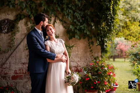 A Tender Kiss On The Head Inside An Old Shed In Gorizia In an old shed in Gorizia, Italy, the groom kisses the bride on the head while they embrace, conveying tenderness and intimacy during their couple portraits.