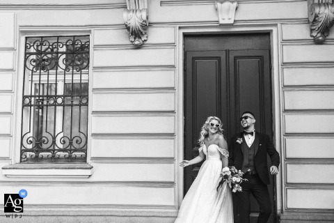 Sharing Joy Back To Back At The National Art Gallery In Sofia Near the gardens of the National Art Gallery in Sofia, the couple stands back to back, laughing and playfully glancing over their shoulders, their joyful energy mirrored by the outdoor setting.