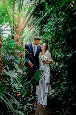 Amidst Botanic Garden Foliage in Sofia, Couple Shares Quiet Togetherness Surrounded By Nature’s Tranquil Beauty Amid the lush foliage of University St. Kliment Ohridski Botanic Garden in Sofia, a couple faces each other in quiet togetherness, surrounded by vibrant greenery and tranquil nature.
