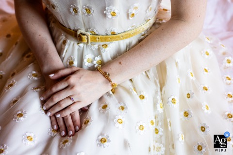 At the Grand Hyatt in Kyoto, Japan, the bride's wedding details are elegantly captured with a gold bee bracelet resting against the floral texture of her white gown, creating a refined image that highlights the thoughtful details of her wedding day.