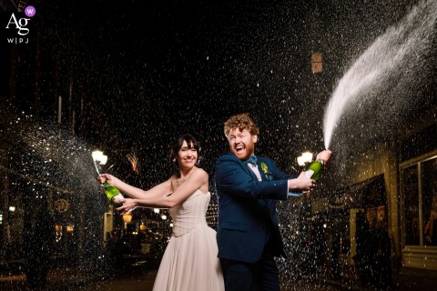 At The Society Room in Hartford, Connecticut, the bride and groom celebrate the end of their wedding night with a jubilant champagne spray, creating a lively portrait filled with energy, laughter, and sparkling celebration.