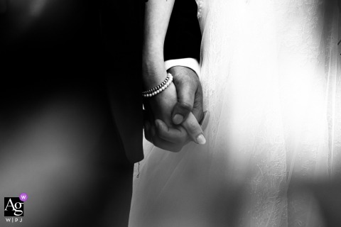 At Casa Celincordia in Cesena, Italy, the couple holds hands during the ceremony in a black-and-white detail image, emphasizing touch, commitment, and the quiet emotion of their vows.