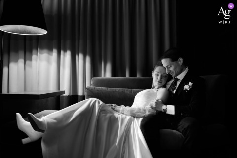 At Zahav in Philadelphia, Pennsylvania, the newlyweds share a quiet black-and-white portrait on a sofa, where soft window light and gentle shadows create an intimate moment of closeness away from the energy of the wedding celebration.