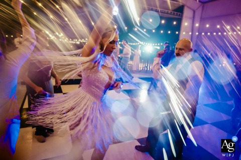 At the Sandford Orlando Airport reception in Florida, the dance floor comes alive with light-up wands and colorful DJ lighting, creating a high-energy wedding scene filled with motion, celebration, and visual impact.