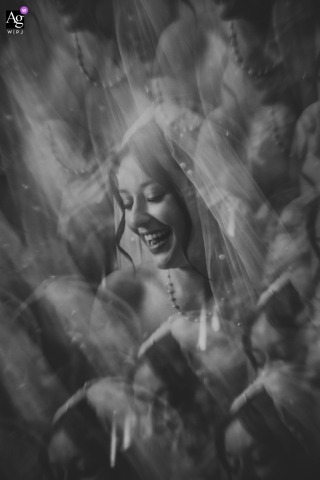 At the Mairie de Fleury-les-Aubrais in France, the bride's joyful smile glows through layers of soft reflections in a striking black-and-white portrait, where creative framing and light transform a simple expression into an artistic wedding-day image.